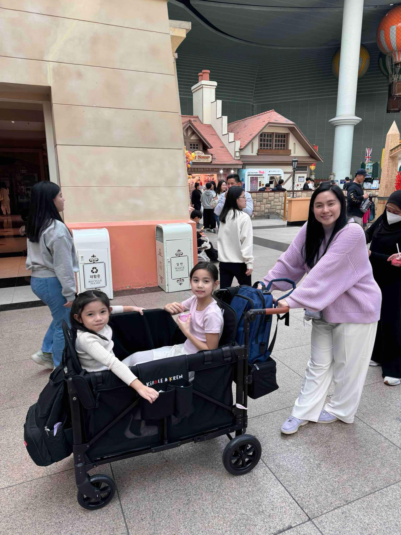 mariel padilla with his son inside a kibble and krew stroller wagon