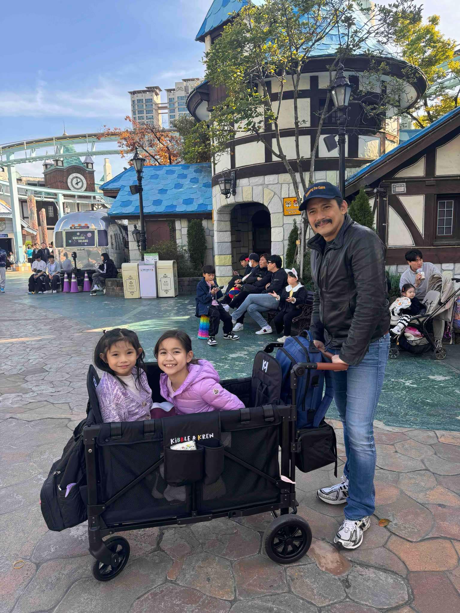 robin padilla with his daughters in a stroller wagon by kibble and krew